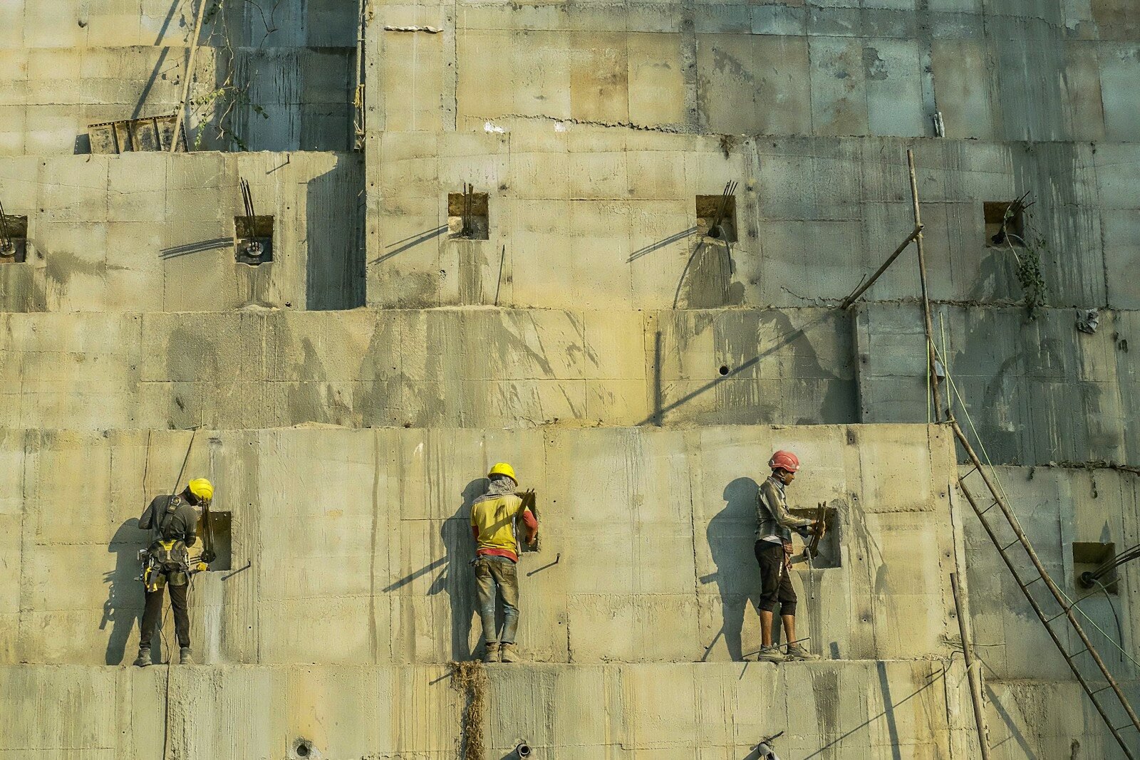 a group of men standing on top of a cement wall